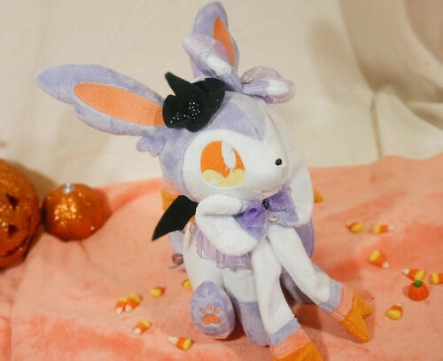 Halloween Sylveon (2018) Sylveon plush with a lavender and orange color scheme and tiny witches' and bat wings
